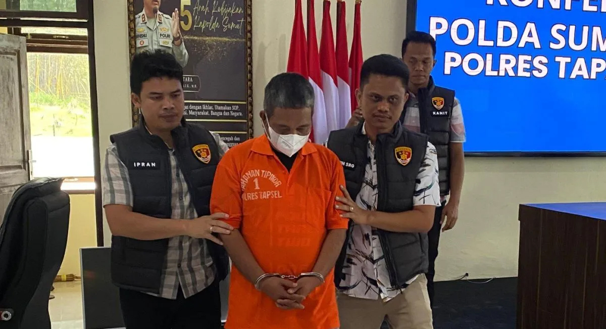 Mantan Kades memakai baju tahanan saat digiring petugas.