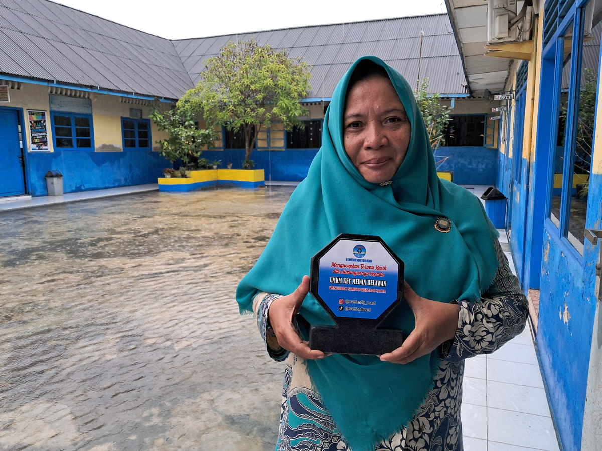 Pujiati, Kepala Sekolah SD Hangtuah 1 Belawan, memamerkan plakat hasil daur ulang dari sampah plastik.