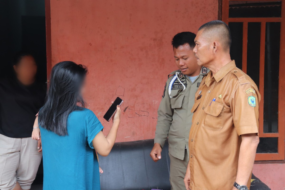 Satpol PP memeriksa identitas penghuni kos-kosan.