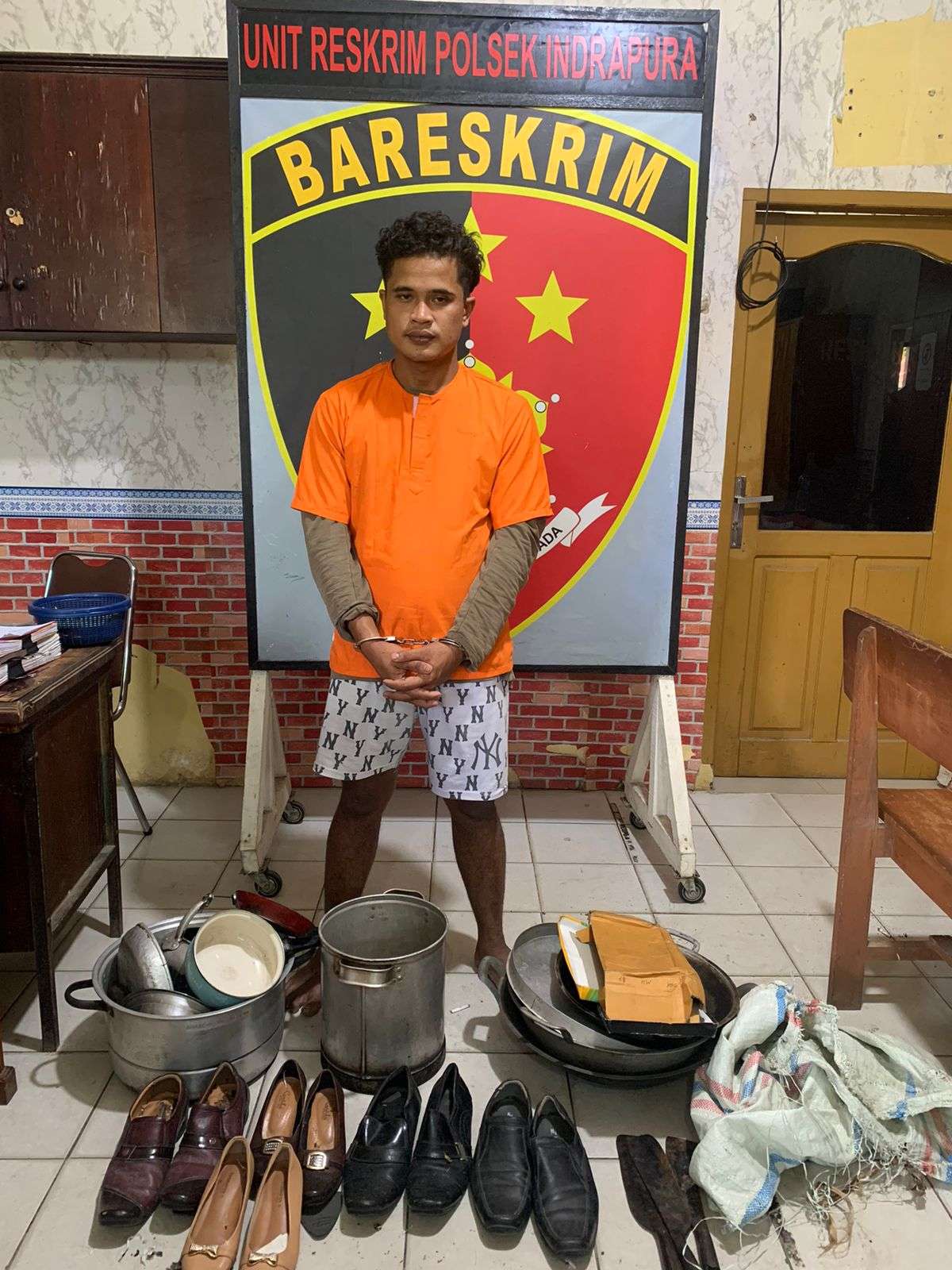 Tersangka pembobol rumah dinas GPDI bersama barang bukti.