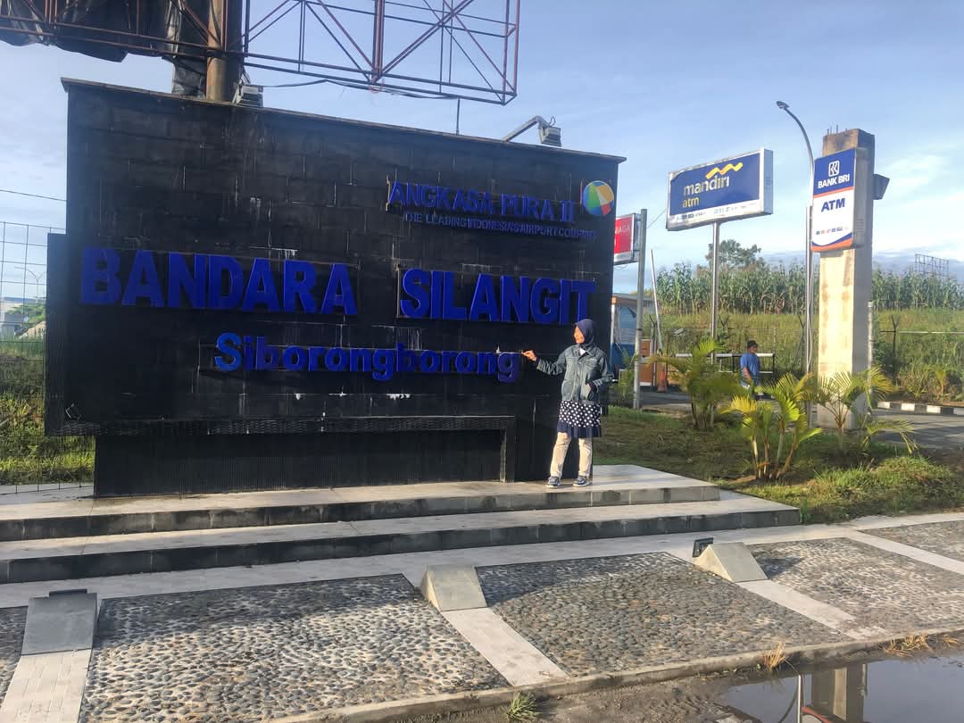 Papan nama Bandara Internasional Silangit, yang terletak di Siborong-Borong yang tampak gelap dan sulit dibaca dari jauh.
