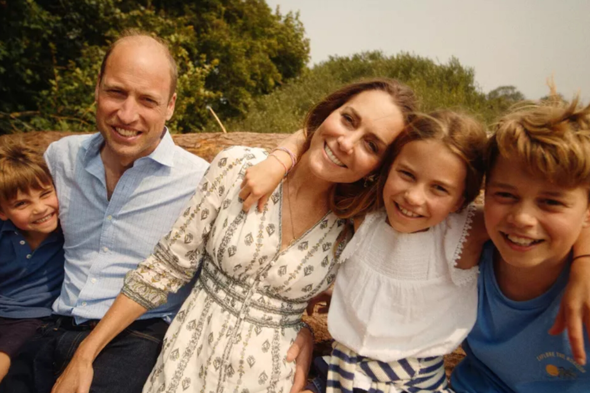 Kate dan William terlihat duduk santai dengan anak-anak mereka, saling berpegangan tangan,