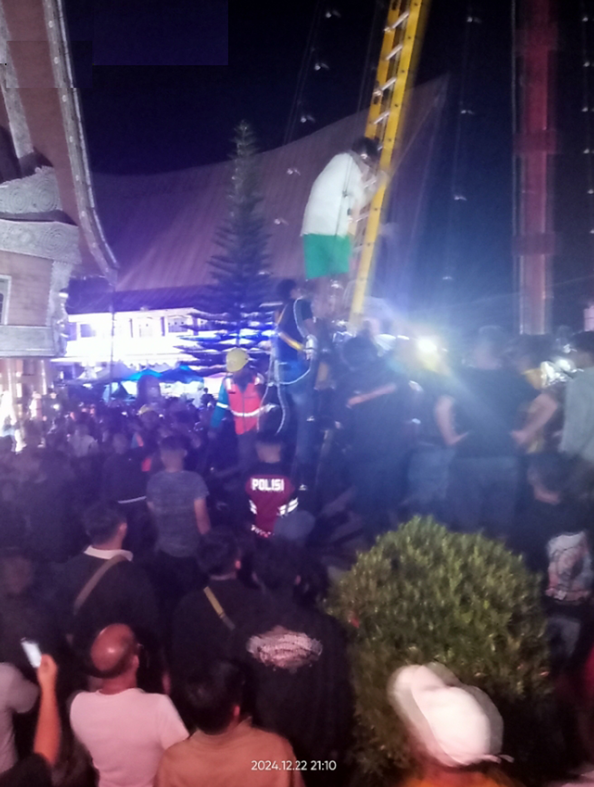 Seorang pria stres nekat memanjat tiang lampu Natal di Taman Kota Tarutung.