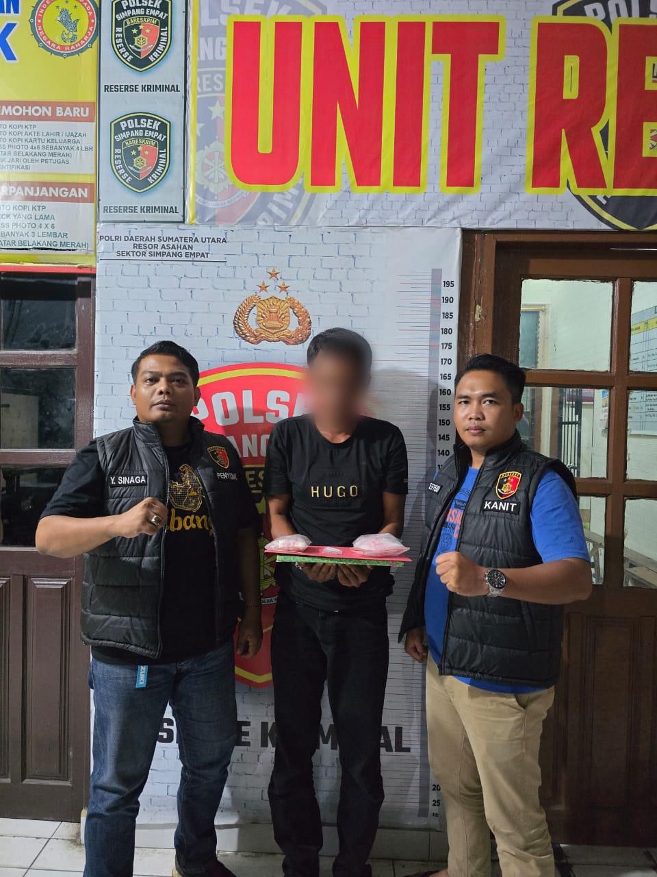 Tersangka (tengah) dan barang bukti diapit petugas.