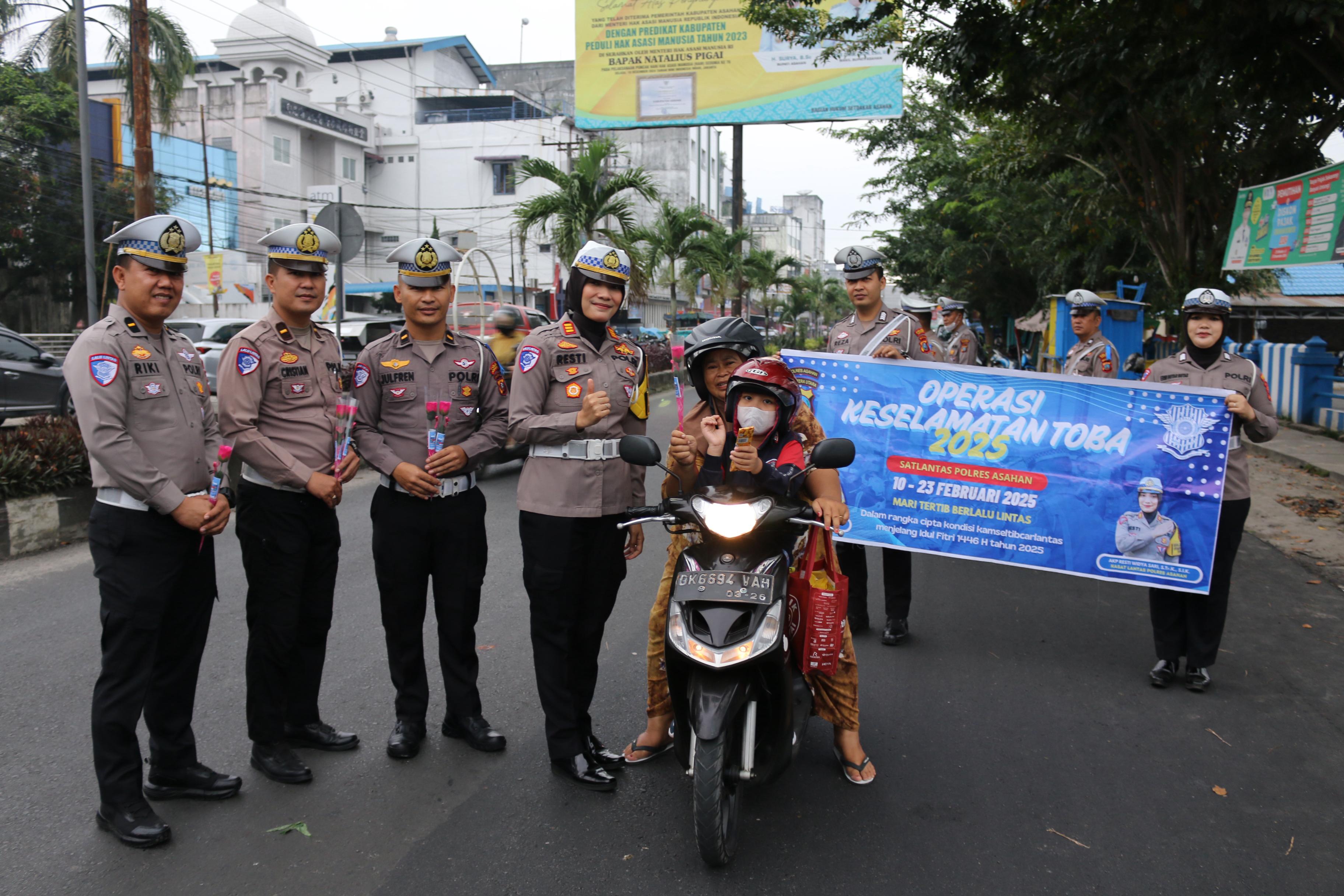 Kasat Lantas Polres Asahan AKP Resti Widya Sari saat membagikan bunga dan cokelat.