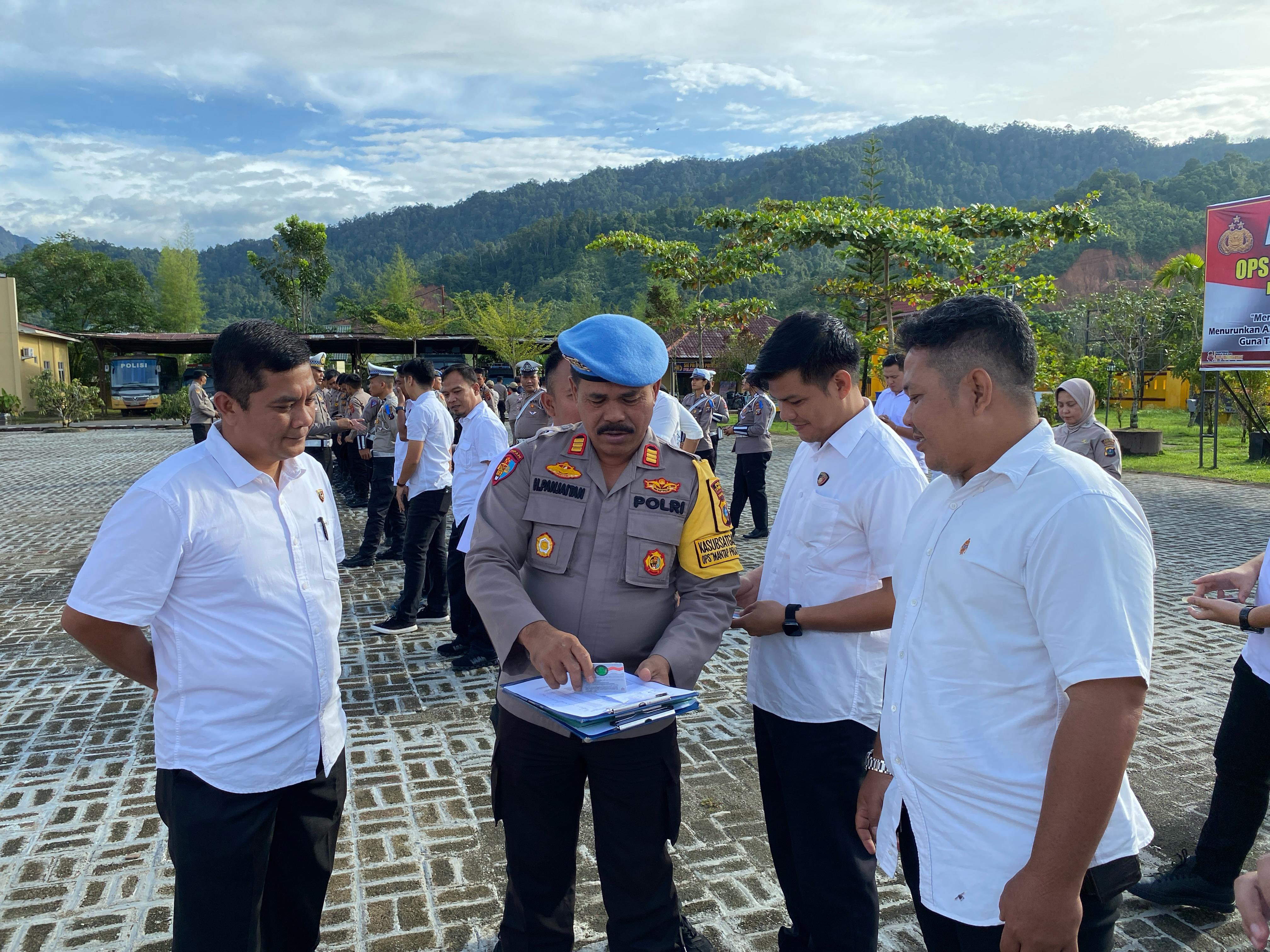 Kasi Propam Polres Tapteng, AKP Heriyanto Panjaitan, memeriksa hape personil di Lapangan Apel Polres Tapanuli Tengah.