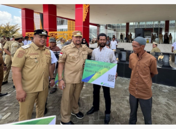 Bupati Batubara Baharuddin Siagian secara simbolis menyerahkan kartu BPJS Ketenagakerjaan kepada pekerja rentan.