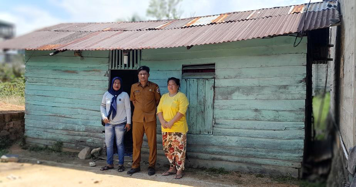 Lurah, Kepling, dan warga Lubuk Tukko foto bersama di depan rumah penerima manfaat Program Bedah Rumah.
