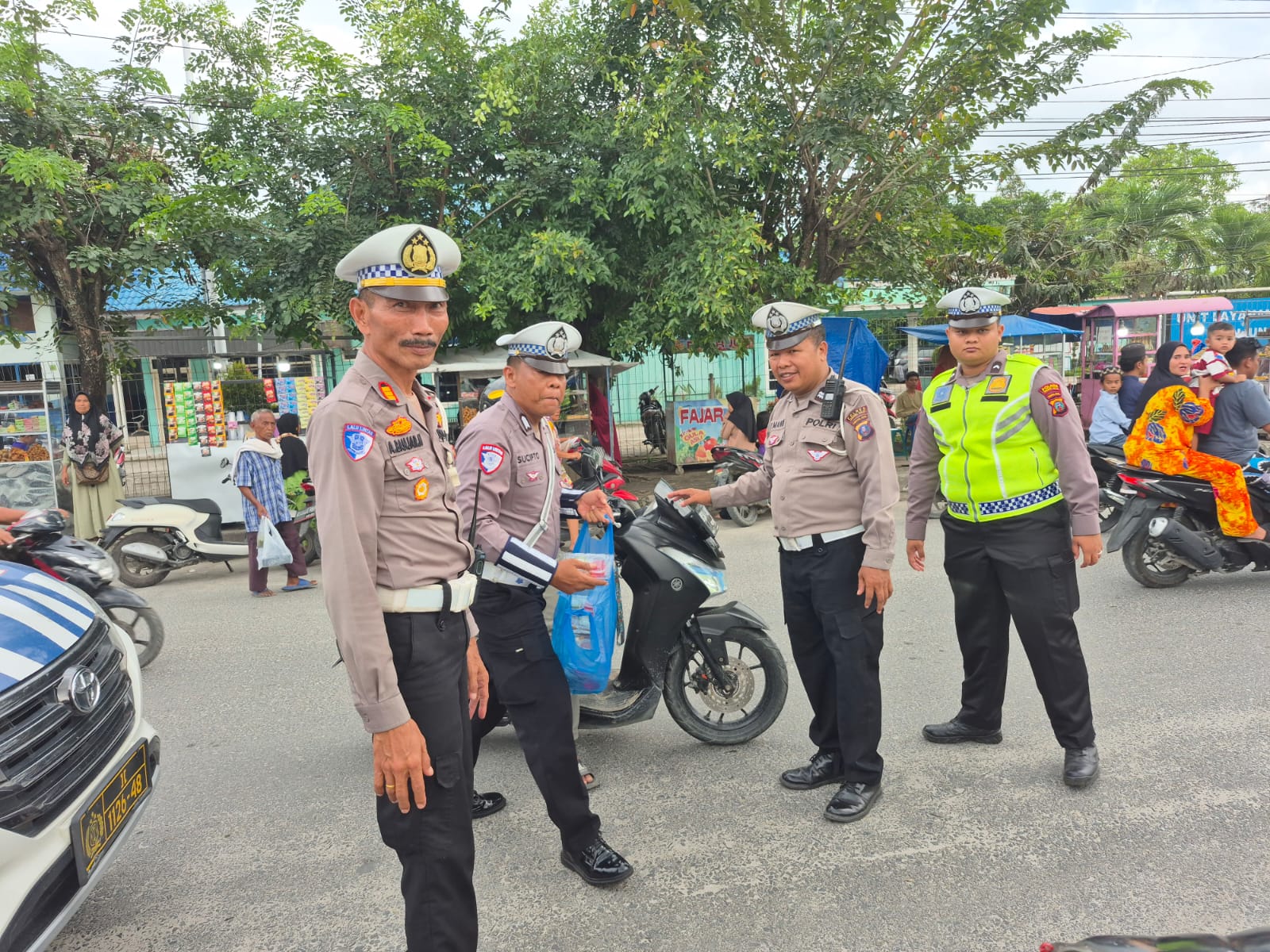 Personil Satlantas Polres Tanjungbalai membagikan takjil kepada pedagang di pinggir jalan.