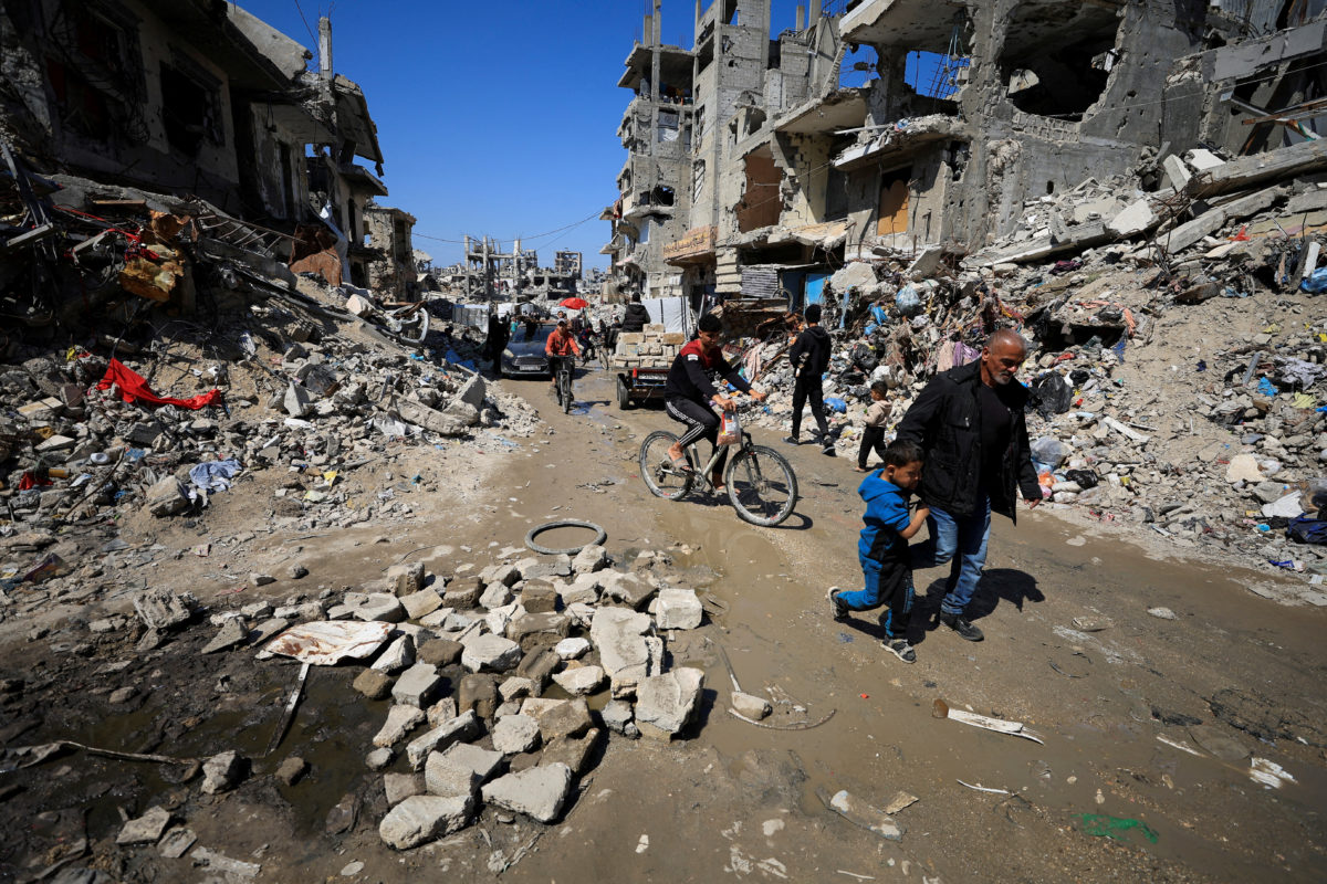 Warga Palestina berjalan melewati puing-puing rumah yang hancur, di Kota Gaza, 11 Maret 2025.