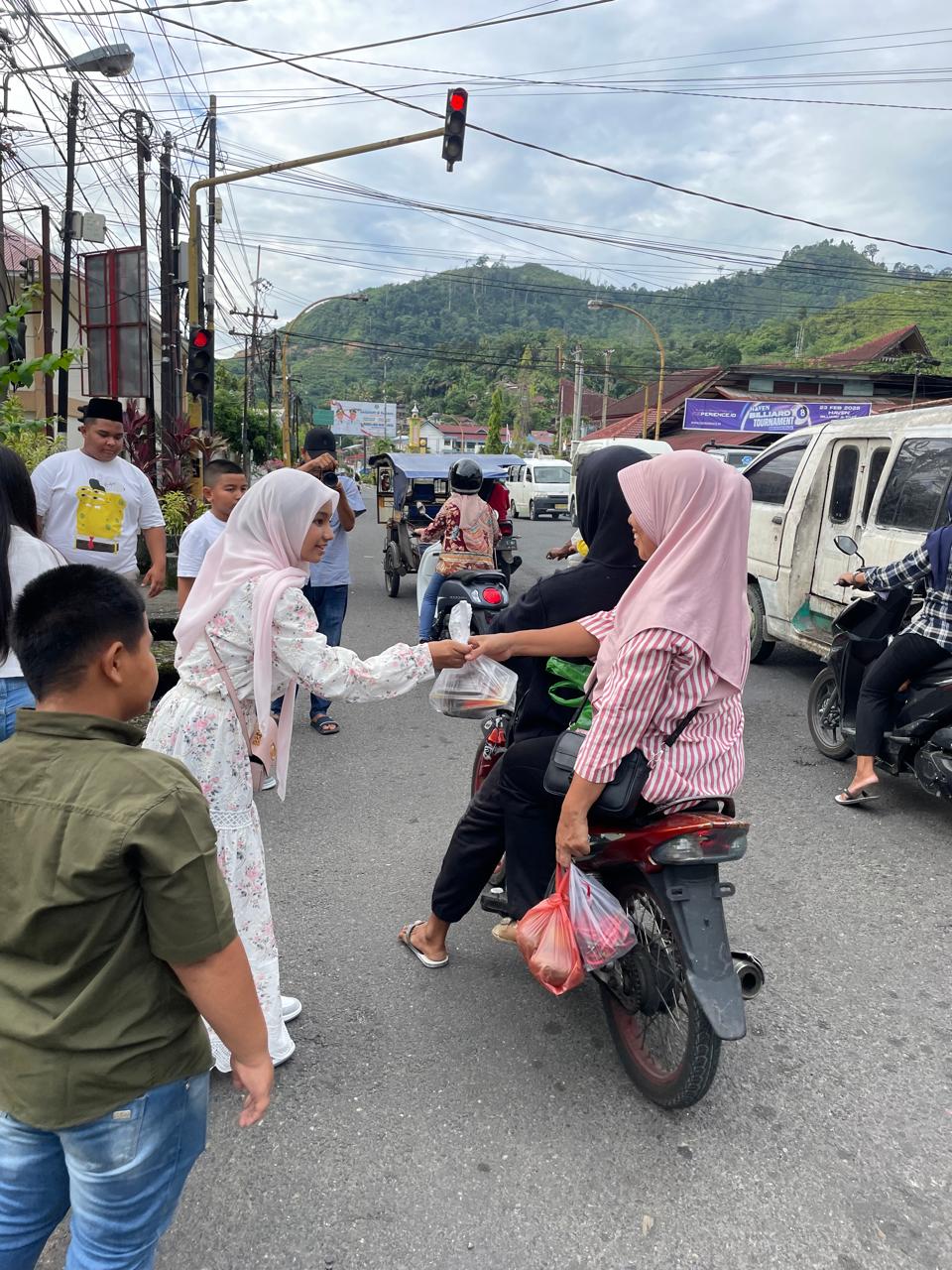 Annisa Bakhtiar Sibarani, Putri Tari Cilik Indonesia 2024 berbagi takjil atau makanan berbuka puasa di lampu merah Pandan, Tapanuli Tengah, Sumut.