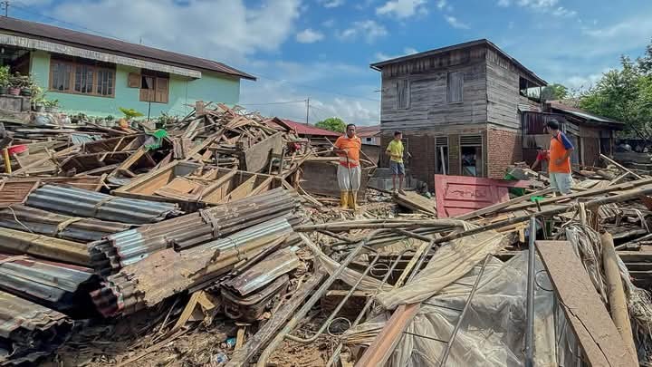 Rumah yang dilanda banjir dan material yang masih belum dibersihkan.