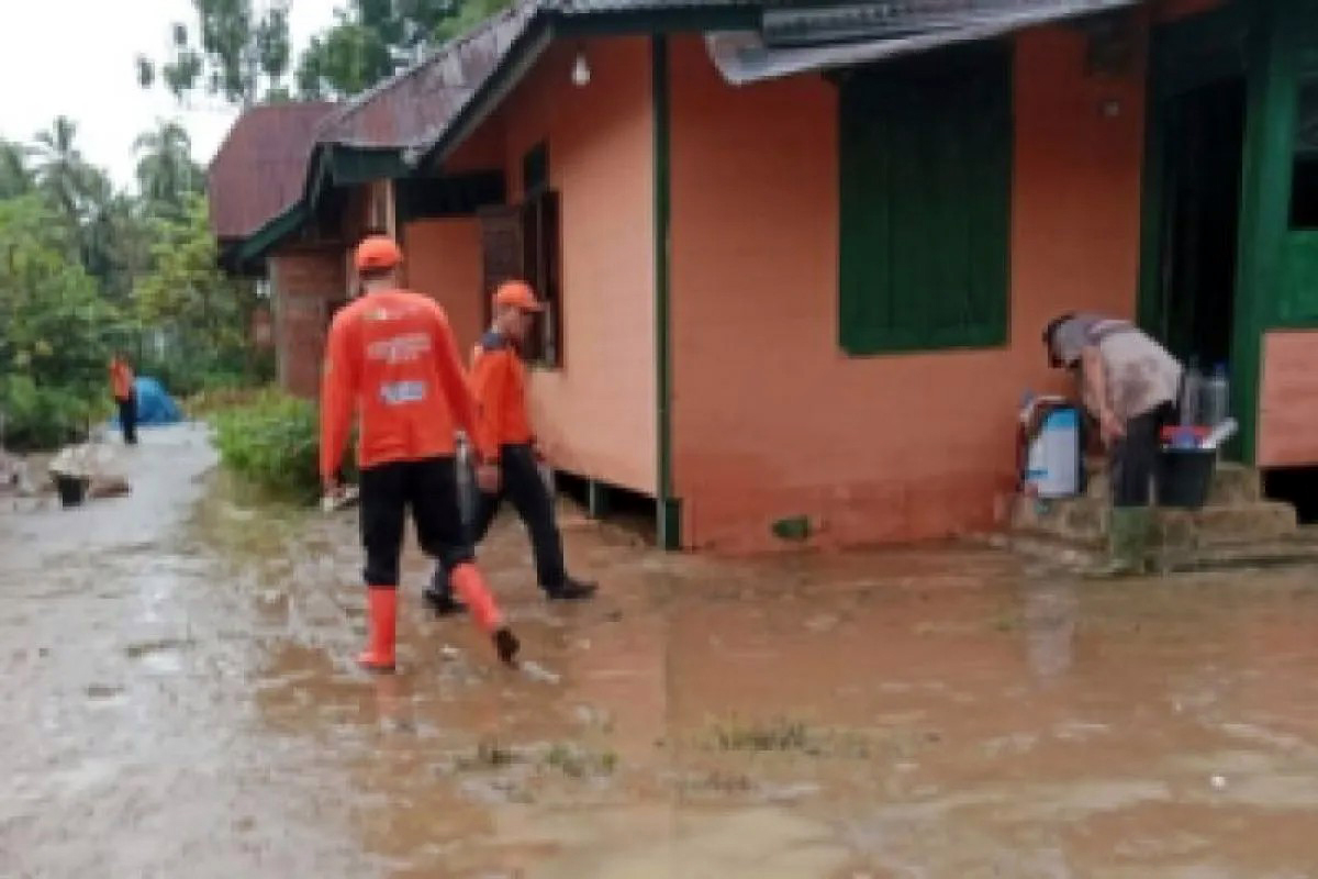 Warga dan petugas BPBD melakukan pembersihan material banjir yang merendam rumah warga.
