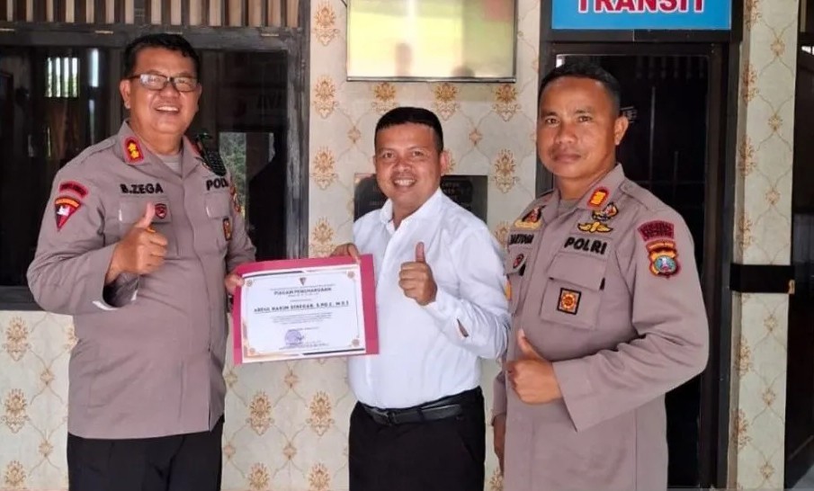 Abdul Hakim Siregar (tengah) menerima penghargaan yang diserahkan Komandan Batalyon C Brimob Polda Sumut, AKBP Dr Buala Zega.