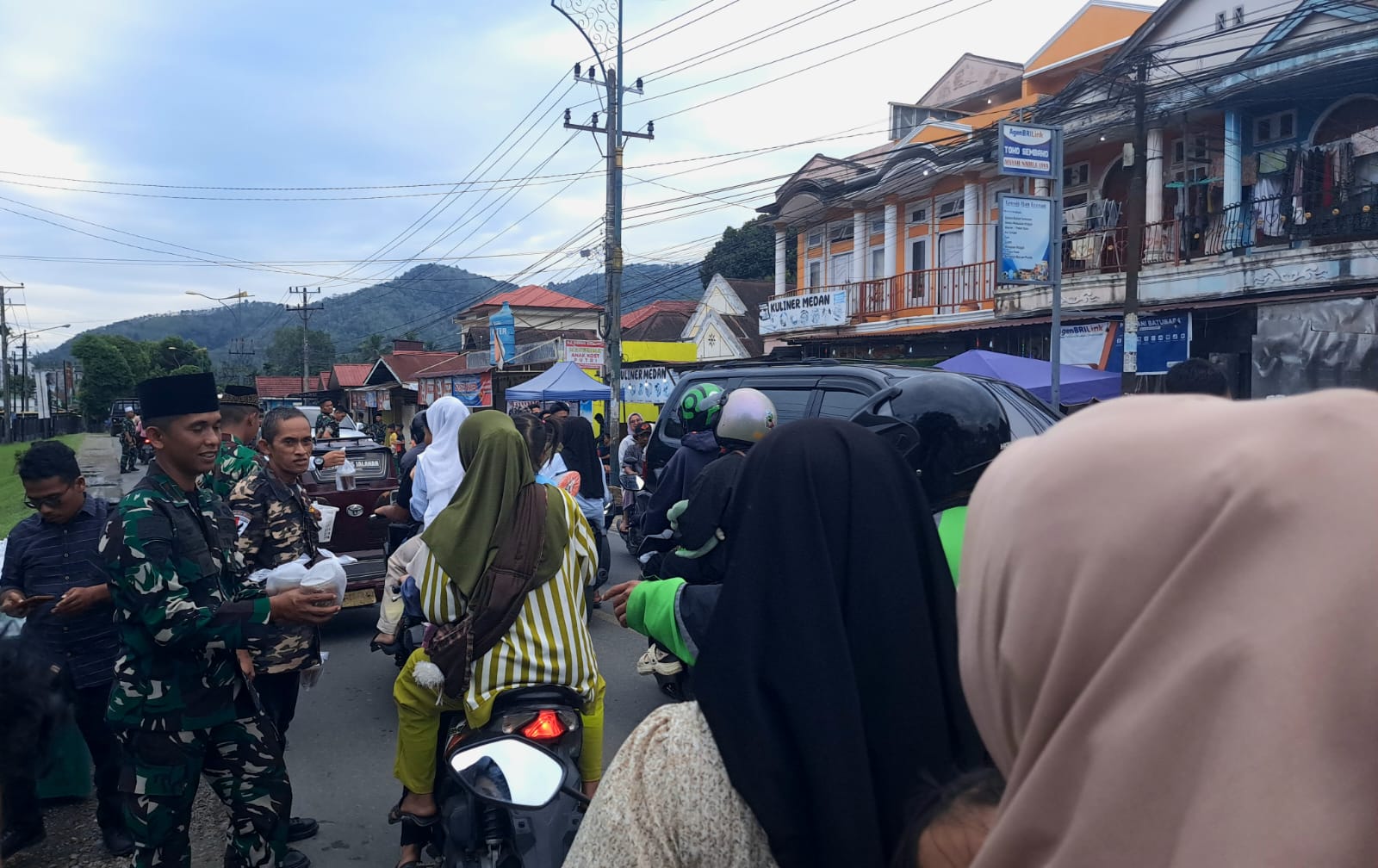 Wadanyonif membagikan takjil kepada pengendara ojol, Jumat (28/3/2025), di Jalan Imam Bonjol Kota Padangsidimpuan. (Samman/MetroDaily)