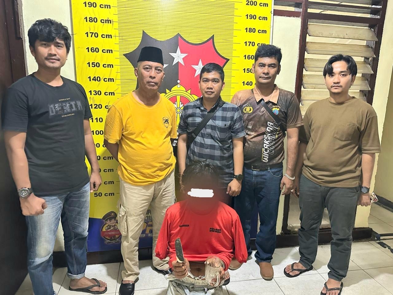 Tersangka pelaku penganiayaan (baju merah).