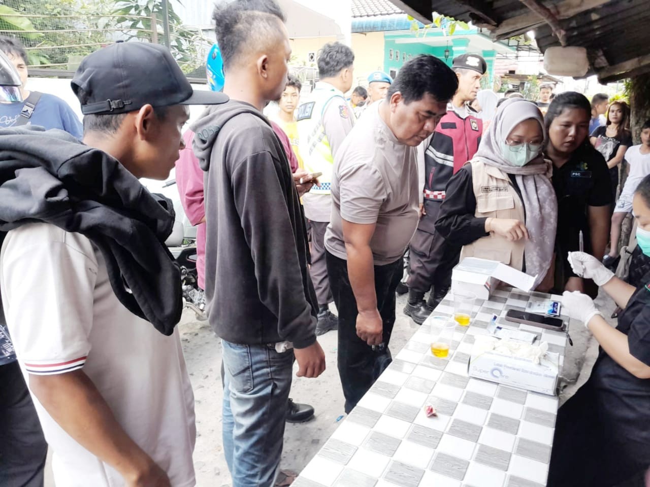 Tes urine di lokasi penggerebekan sarang narkoba.