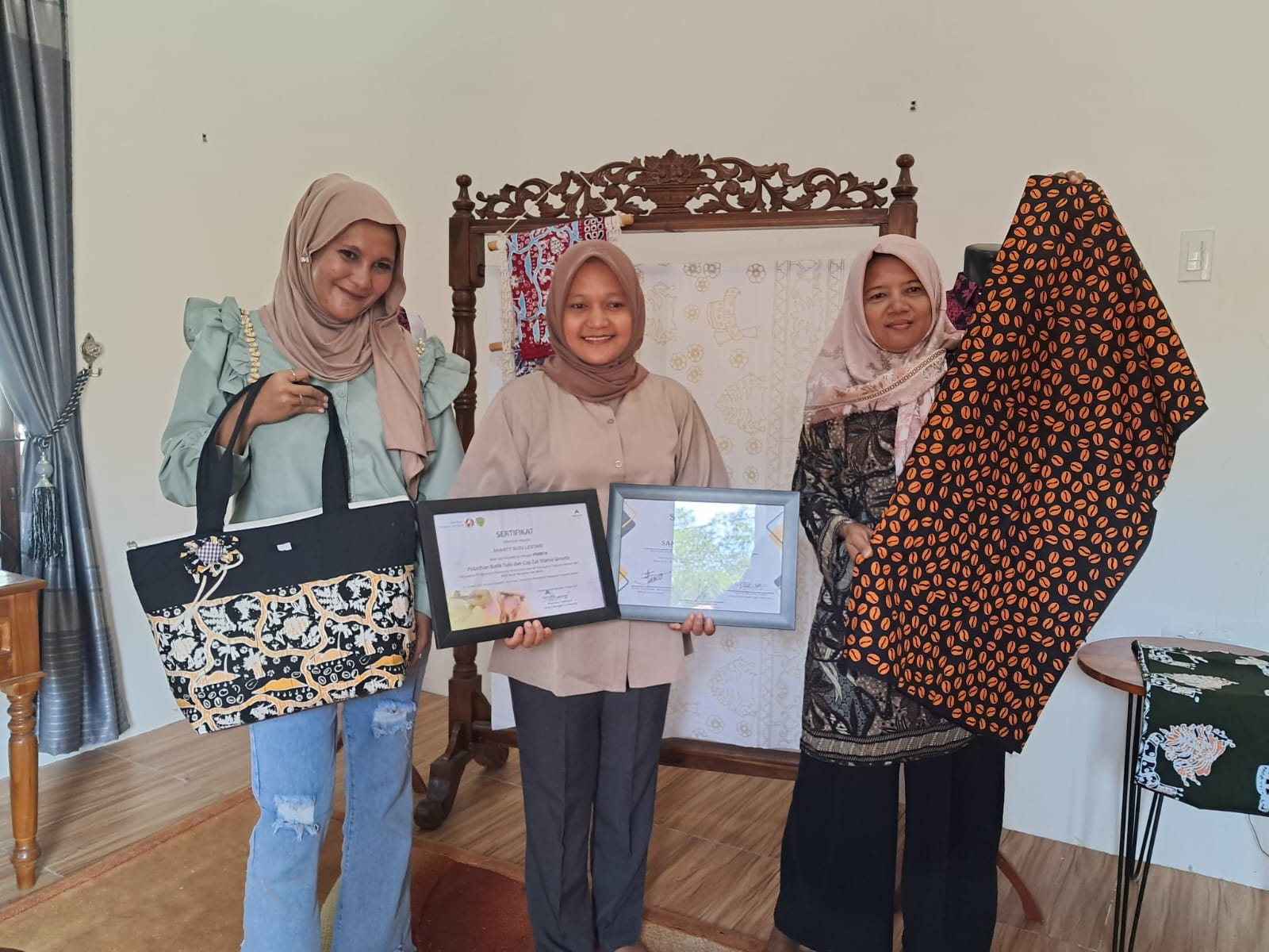 Santi Budi Lestari (tengah) memegang plakat penghargaan untuk KUB Tapsel, foto bersama anggota KUB yang memamerkan batik bergambar ikonik Tapsel.