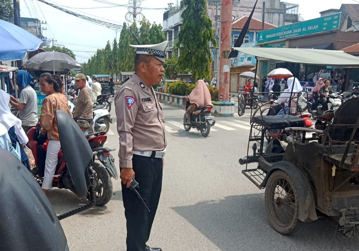 Personil Satlantas Polres Tanjungbalai sedang mengatur lalulintas di siang hari.