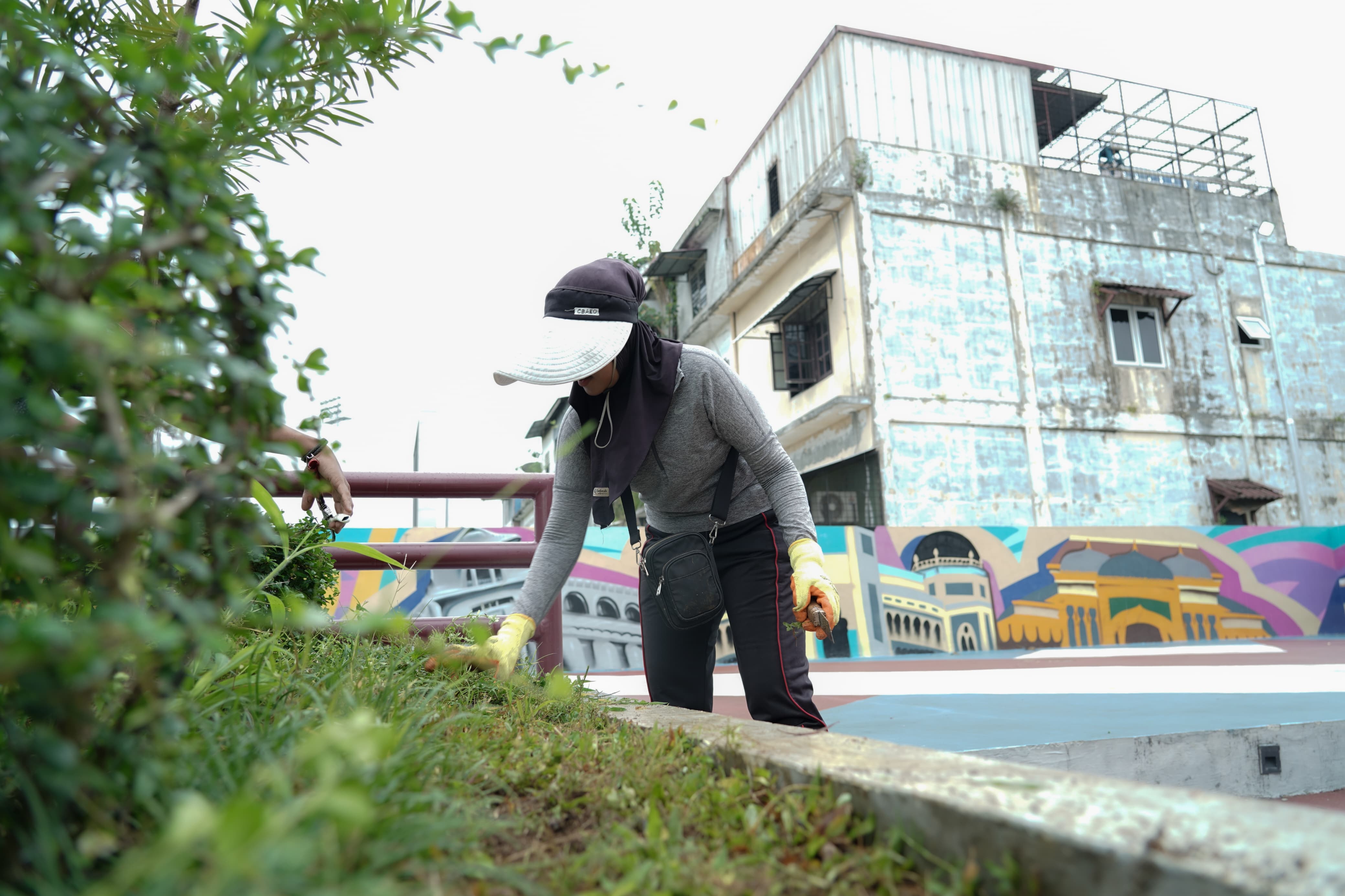 Petugas kebersihan mencabut rumput di Urban Community Park Kebun Bunga, Medan Petisah, usai direvitalisasi Pemko Medan.