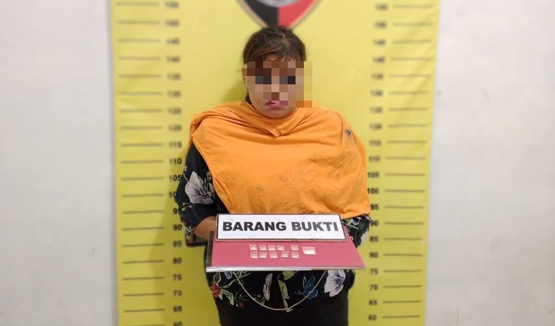 Tersangka ARP saat diamankan polisi beserta barang bukti.