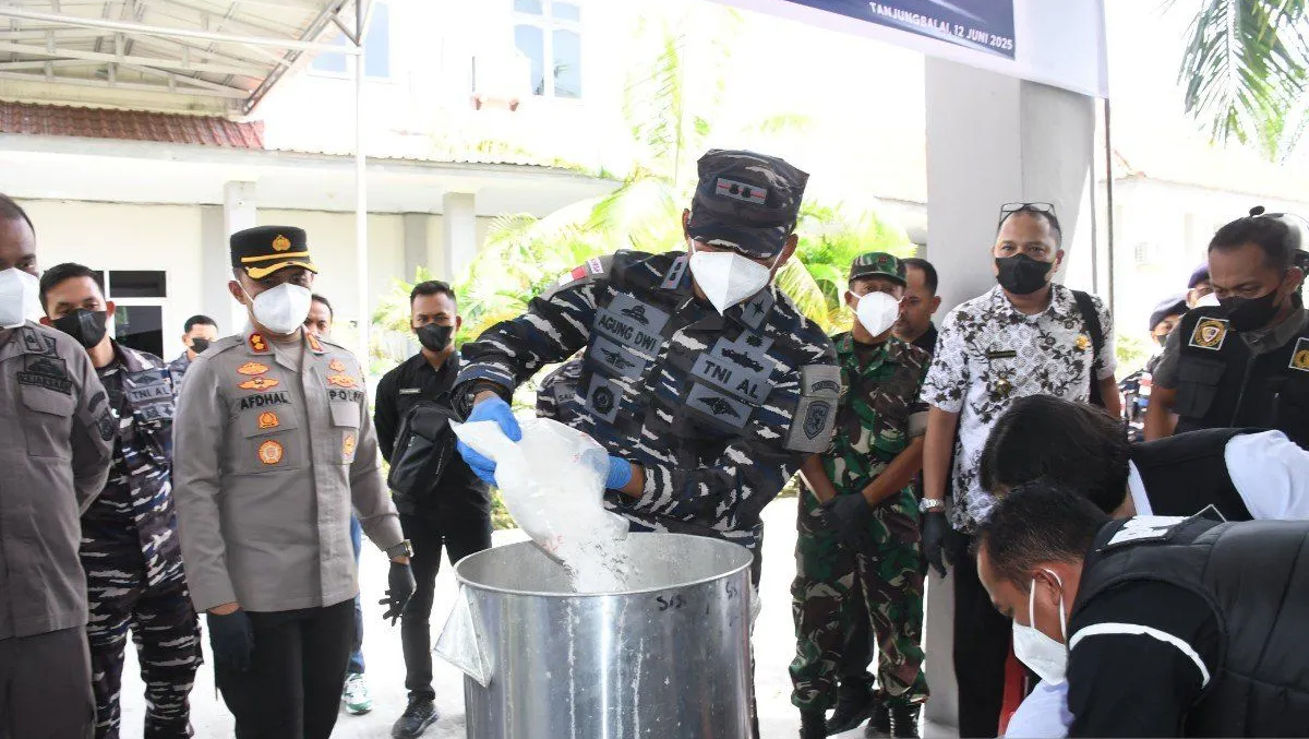 Komandan Lanal TBA, Letkol Laut (P) Agung Dwi H.D menuangkan kristal putih merupakan sabu selundupan dari Malaysia ke dalam air mendidih untuk dimusnahkan.