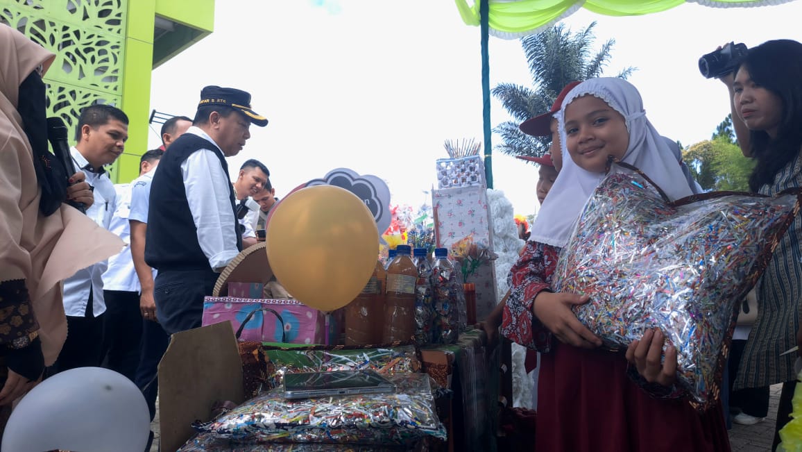 Seorang siswi SDN Telo memamerkan bantal olahan sampah plastik, saat Wakil Bupati Tapsel meninjau stan dalam Peringatan Hari Lingkungan Hidup Sedunia 2025, Rabu (25/6/2025) di Lapangan Menara Pandang