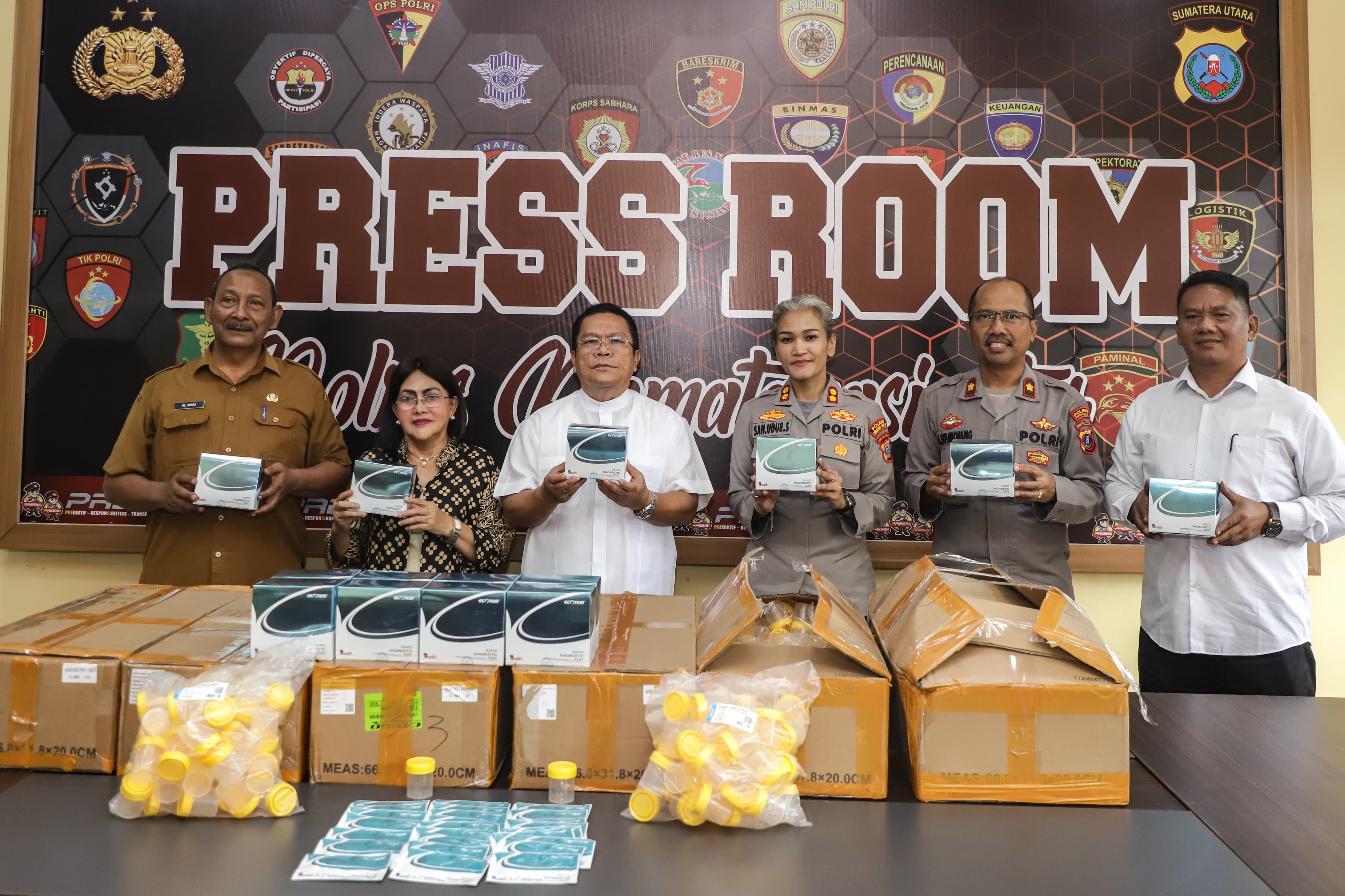 Wali Kota Pematangsiantar Wesly Silalahi didampingi Ketua TP PKK Liswati Wesly Silalahi menyerahkan bantuan alat tes urine kepada Kapolres Pematangsiantar AKBP Sah Udur Togi Marito Sitinjak.