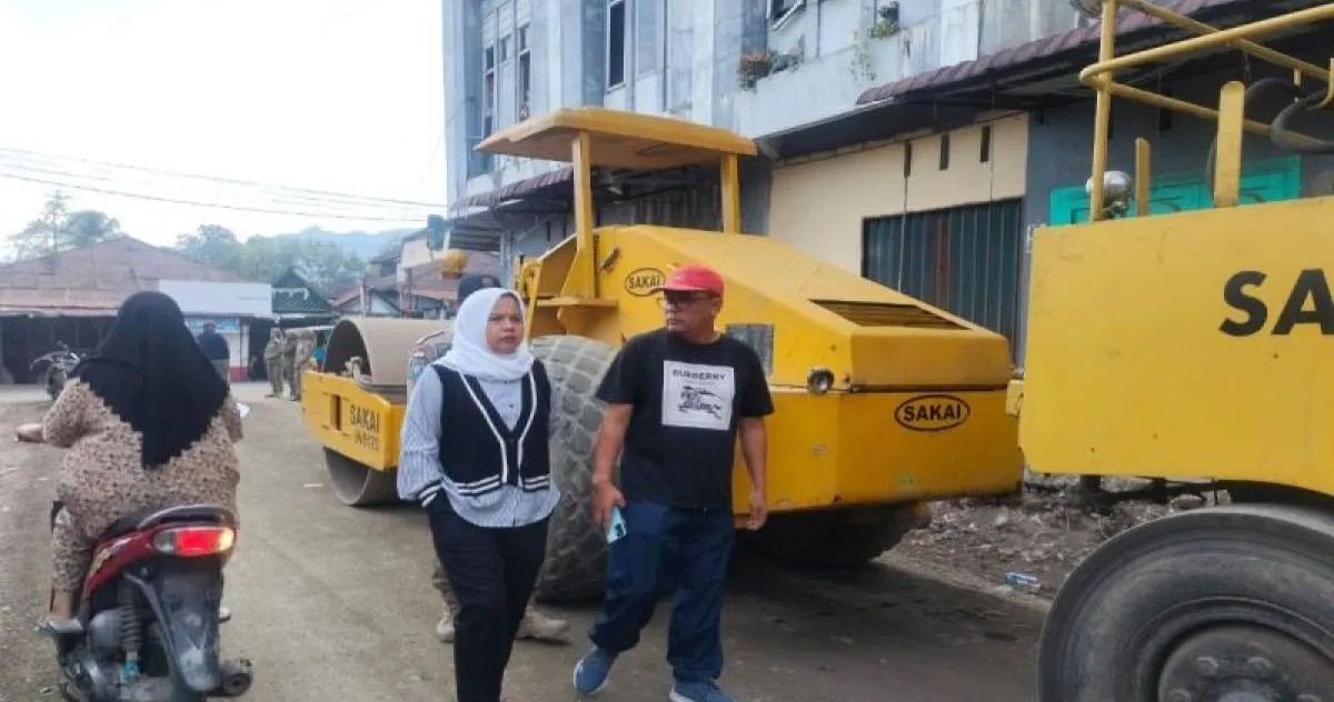 Pj Sekda Madina Sahnan Pasaribu dan Plt Kadis PUPR Elpi Yanti Harahap meninjau pengaspalan jalan keliling pasar lama.