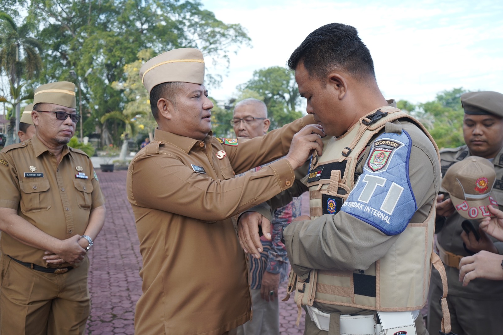 Wakil Bupati Asahan, Rianto SH, MAP, menyerahkan secara simbolis perlengkapan baru kepada petugas Damkar dan Satpol PP usai memimpin Apel Gabungan di halaman Kantor Bupati Asahan, Senin (8/7/2025).