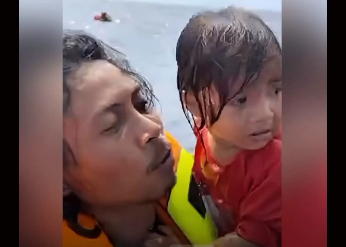 Abdul Rahman Agu terekam menggendong dan menenangkan seorang anak kecil di tengah laut.
