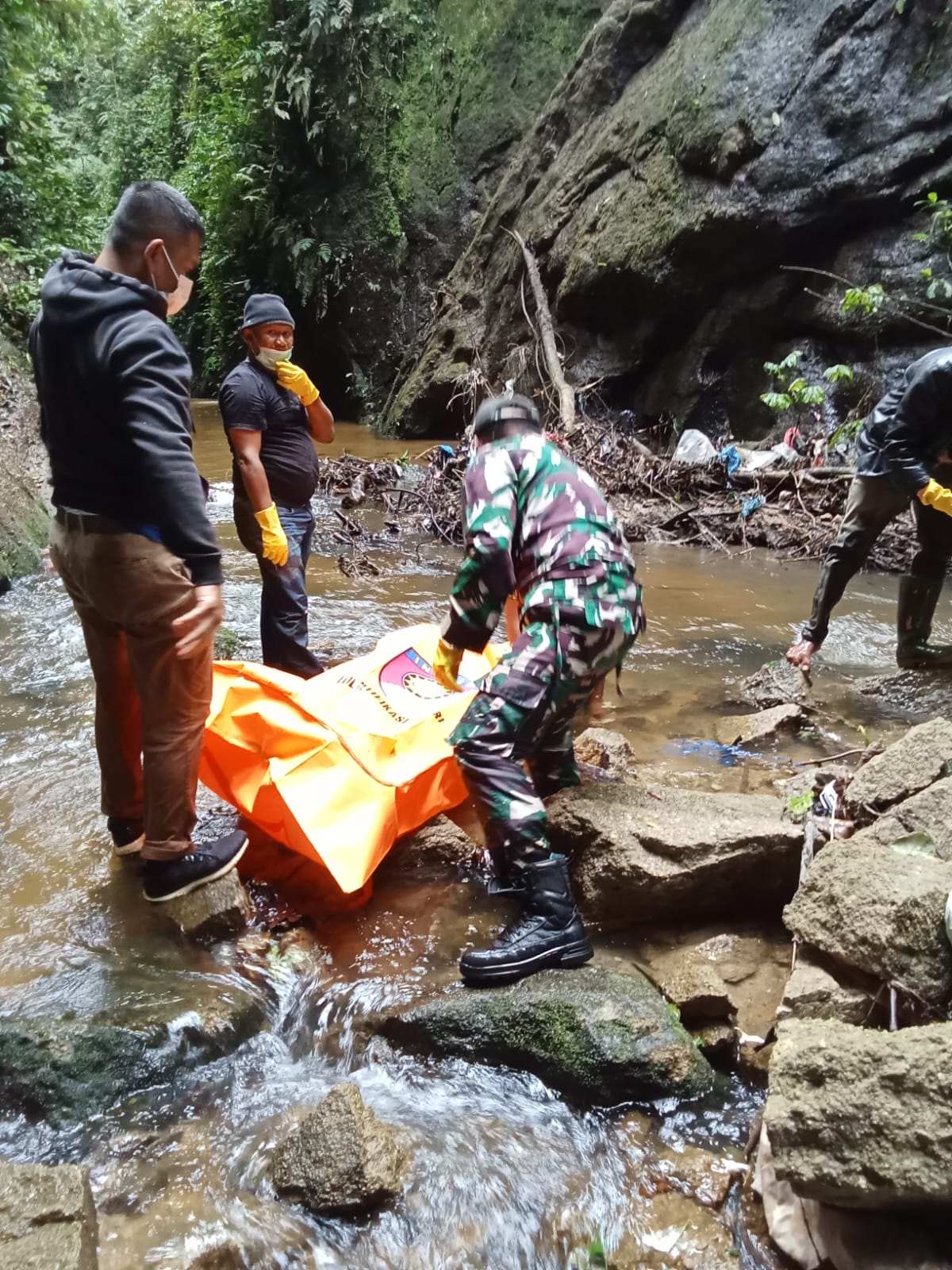 Petugas gabungan mengevakuasi jasad wanita tanpa kepala yang ditemukan tersangkut di aliran Sungai Aek Bolon, Karo, Senin (21/7/2025).