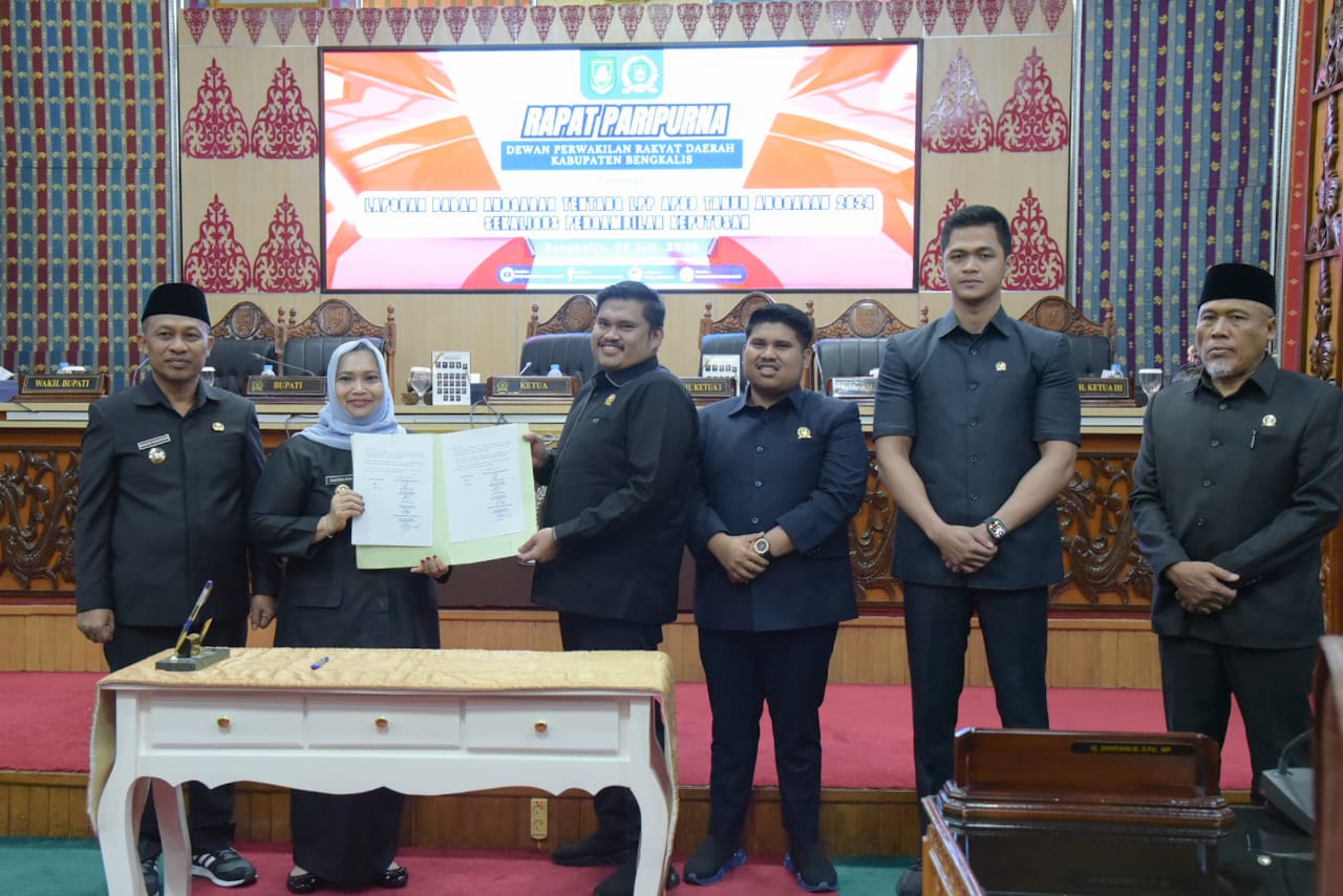 Bupati Bengkalis, Kasmarni, menunjukkan Ranperda Pertanggungjawaban Pelaksanaan APBD Tahun Anggaran 2024 dalam sidang paripurna DPRD Bengkalis, Selasa (22/7/2025).