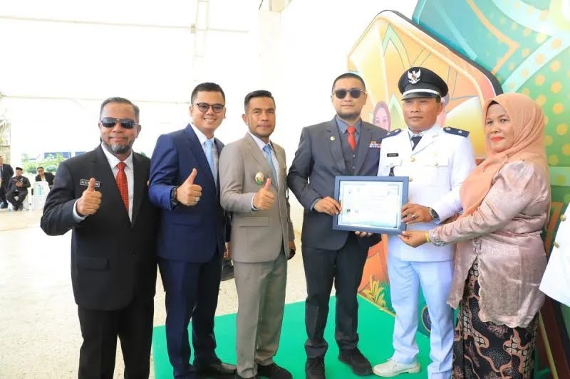 Bupati Labura H Hendri Yanto Sitorus menyerahkan penghargaan kepada para kepala desa terbaik.