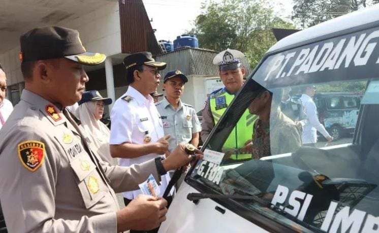 Kapolres Tapanuli Selatan AKBP Yon Edi Winara menempelkan stiker sosialisasi patuh administrasi berkendaraan ke salah satu kaca depan mobil.