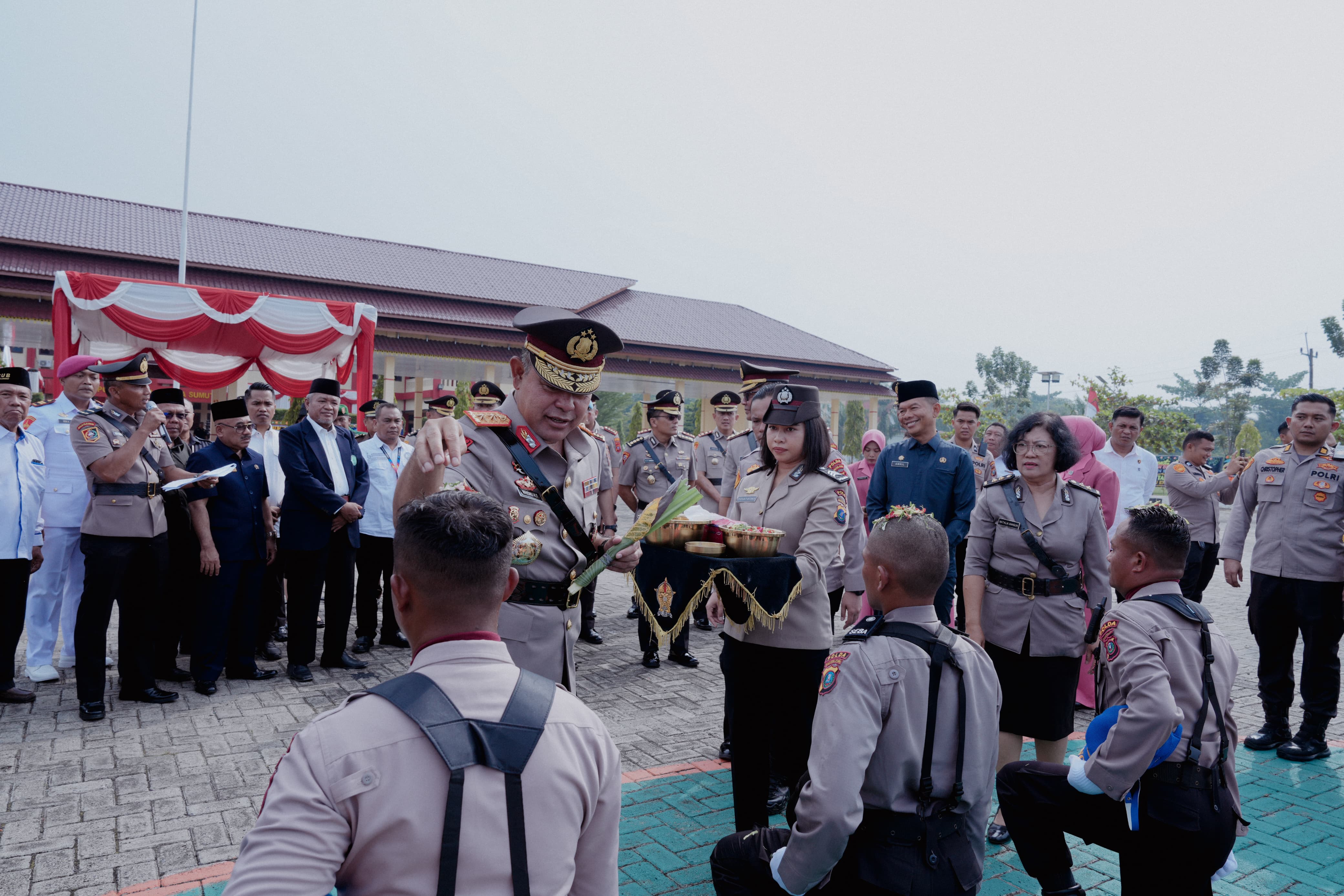 Kapolda Sumut Irjen Pol Whisnu Hermawan Februanto menepung tawari salah satu siswa didik dalam upacara pembukaan Pendidikan Bintara Polri 2025/2026 di SPN Hinai, Langkat.
