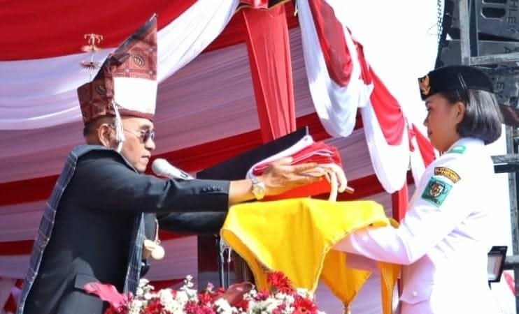 Penyerahan bendera merah putih kepada pembawa baki Paskibraka pada upacara HUT ke-80 Kemerdekaan RI di Simalungun.