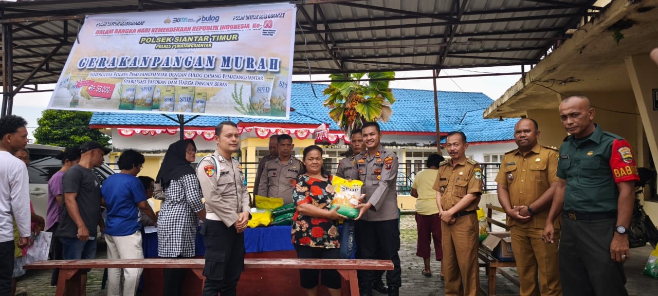 Kapolsek Siantar Timur Iptu Edy JJ Manalu bersama jajaran saat mendistribusikan beras murah kepada warga.