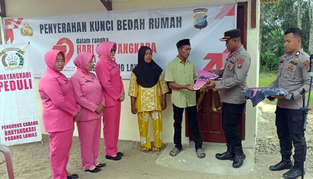 Ahmad Fadilah Pulungan dan istri Nasira menerima kunci rumah baru dari Polres Palas dalam program bedah rumah HUT Bhayangkara ke-79.