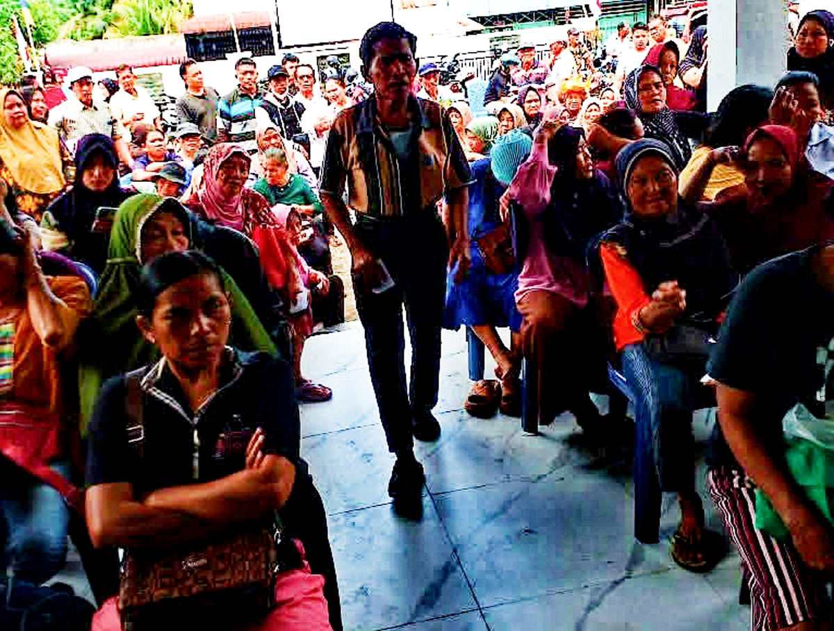 Masyarakat penerima bantuan beras Bulog sedang antre di lokasi distribusi di Simalungun.