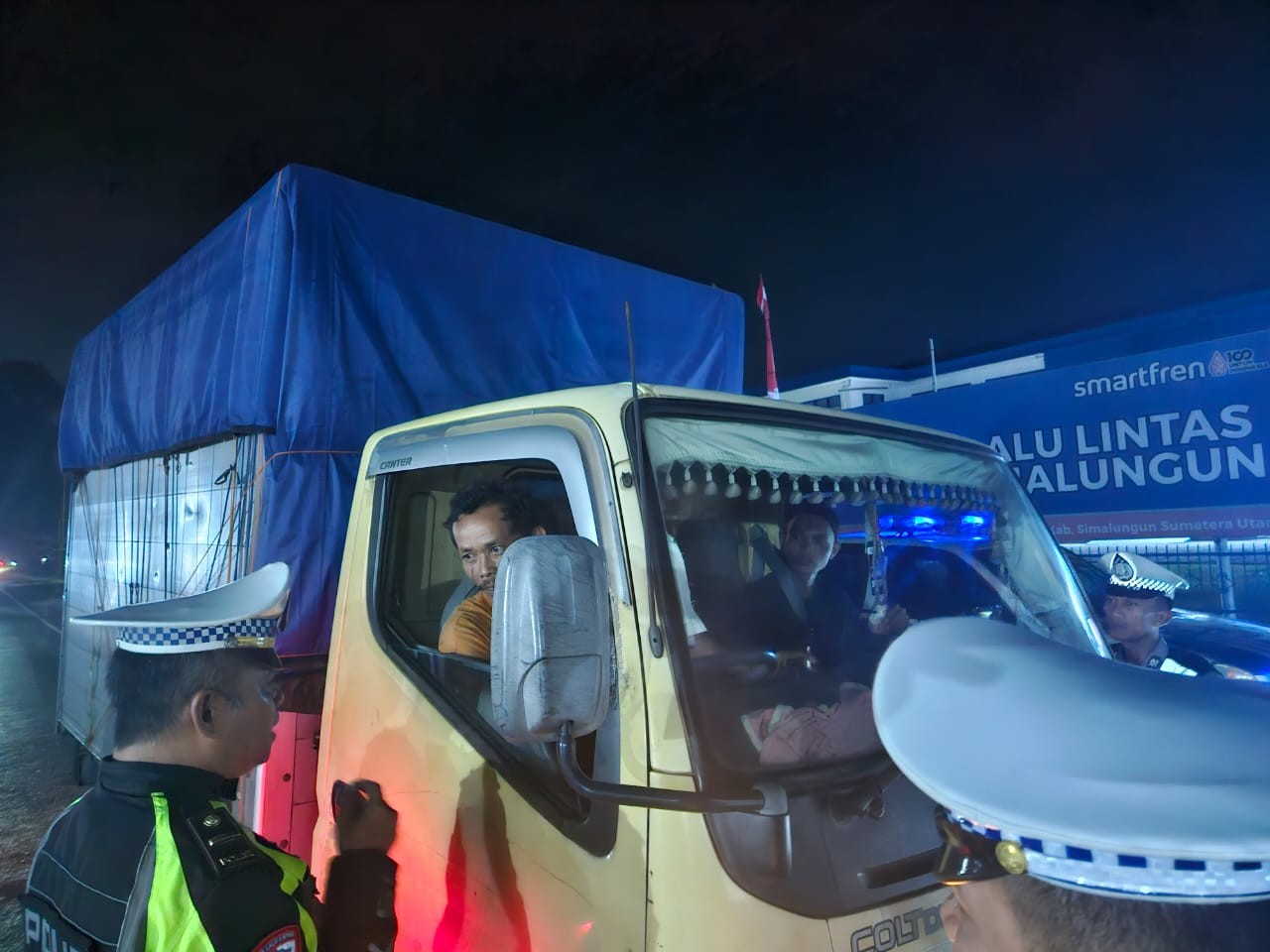 Personel Sat Lantas Polres Simalungun membagikan kopi kepada pengemudi kendaraan.