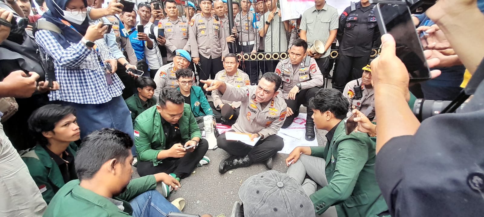 Kapolda Sumut Irjen Pol Whisnu Hermawan Februanto duduk di tanah mendengarkan aspirasi mahasiswa USU saat aksi damai di Mako Polda Sumut, Senin (1/9/2025).