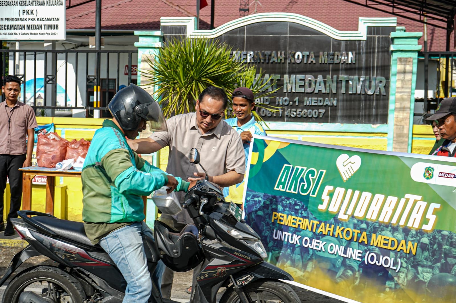 Petugas Kecamatan Medan Timur membagikan sarapan gratis kepada pengemudi ojek online dalam kegiatan Aksi Solidaritas Pemko Medan, Senin (1/9/2025).