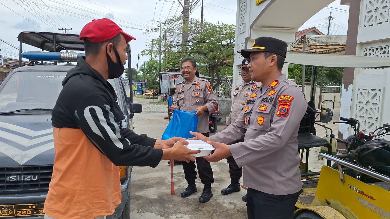 Kapolsek Teluk Nibung AKP Rinaldi Ramadhan membagikan nasi kotak kepada warga dalam kegiatan Jumat Berkah di Tanjungbalai, Jumat (5/9/2025).