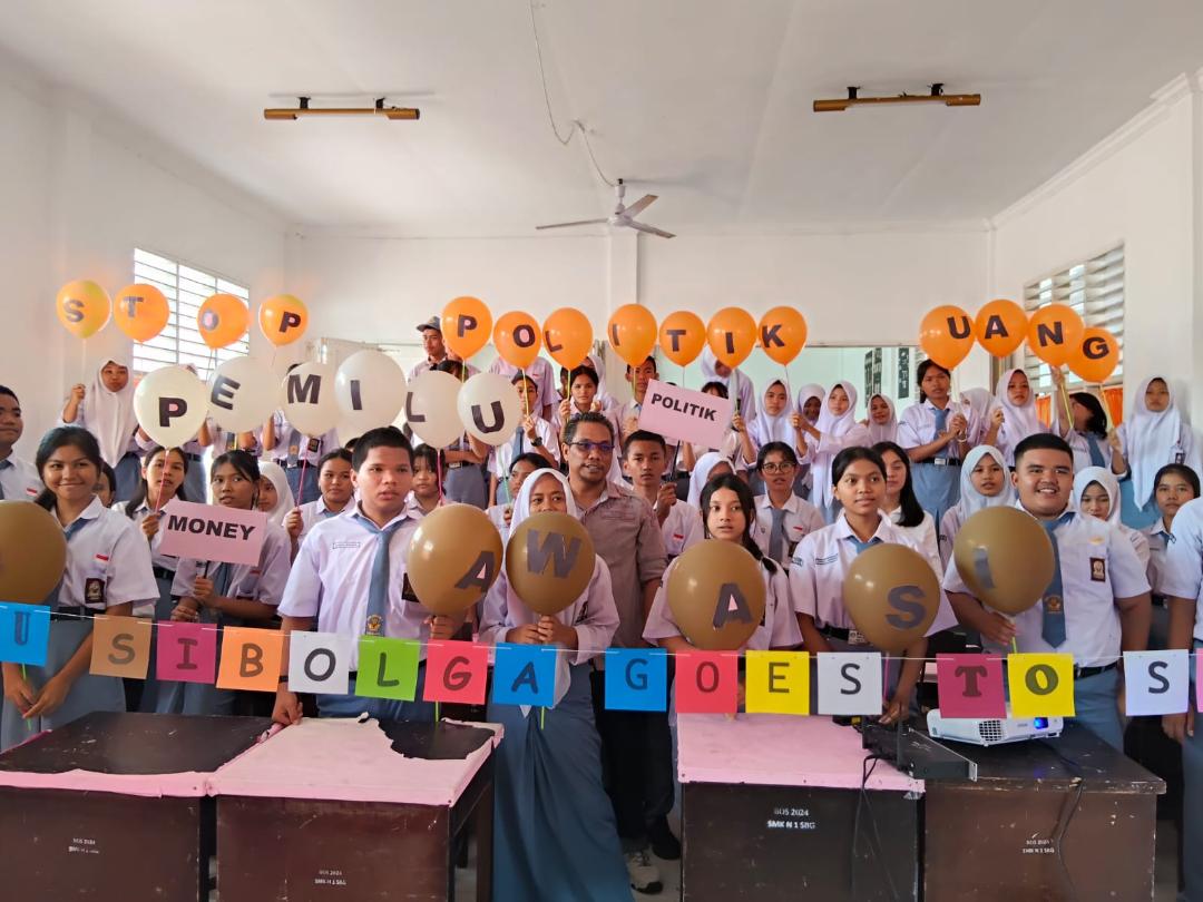 Komisioner Bawaslu Sibolga, Sio Bangun Marganda Sinaga, berfoto bersama siswa-siswi SMKN 1 Sibolga usai kegiatan Goes to School.