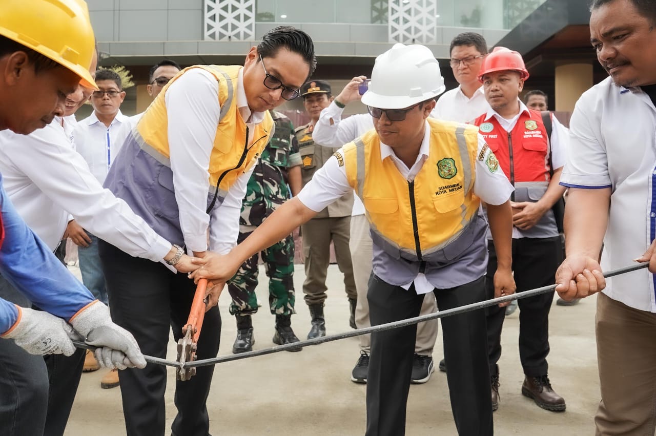 Wali Kota Rico Waas didampingi Plt Kadis SDABMBK Medan, Gibson Panjaitan secara simbolis memotong kabel di Jalan dr Mansyur sebagai tanda program penanaman kabel dimulai Pemko Medan, Rabu (10/9/2025).