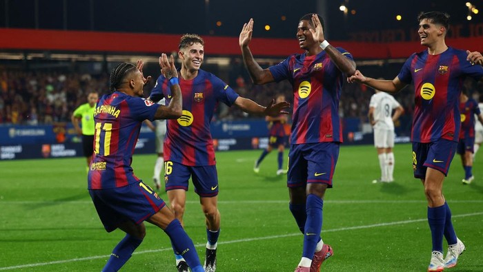 Fermin Lopez, Raphinha, dan Robert Lewandowski merayakan salah satu gol Barcelona saat mengalahkan Valencia 6-0 di Estadio Johan Cruyff, Senin (1592025).