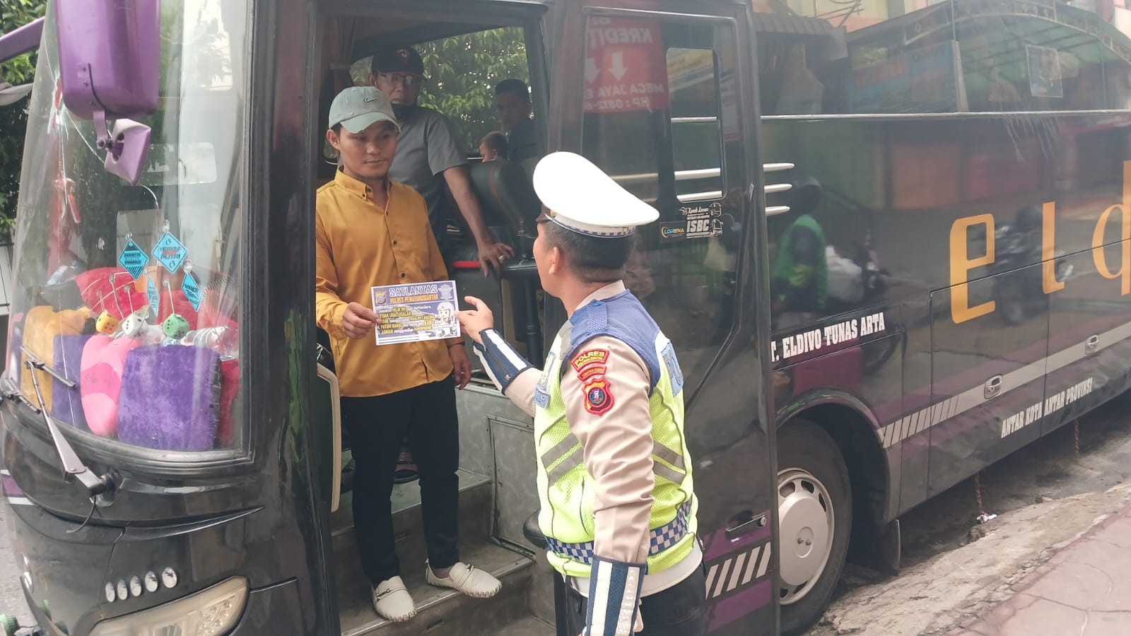Satlantas Polres Pematangsiantar membagikan brosur tertib berlalu lintas kepada sopir bus dan masyarakat di loket Eldivo, Siantar.