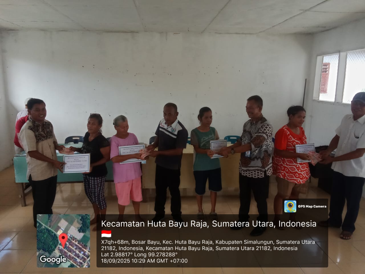 Kepala Desa Bosar Bayu Edu Sitorus menyerahkan BLT kepada warga penerima manfaat di Harungguan Bosar Bayu, Kecamatan Huta Bayu Raja, Kamis (18/9/2025).