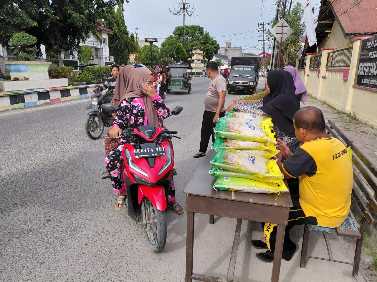 Suasana warga memborong beras dan minyak goreng dalam Gerakan Pangan Murah Polsek Tanjungbalai Selatan, Sabtu (27/9/2025).